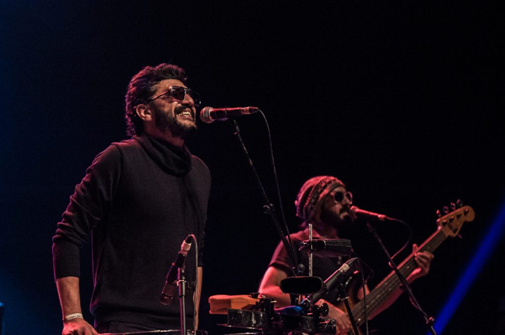 Yazan Al Rousan and Avo Demerjian of Jordanian indie band Autostrad performing on stage, singer at the microphone beside a guitarist under warm stage lighting