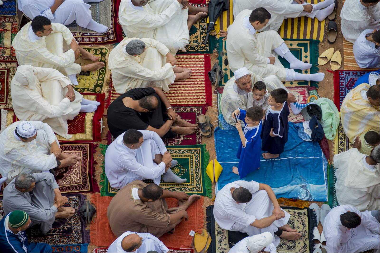 Crowd of worshippers in white and colorful traditional robes gathered for Eid al-Fitr prayer