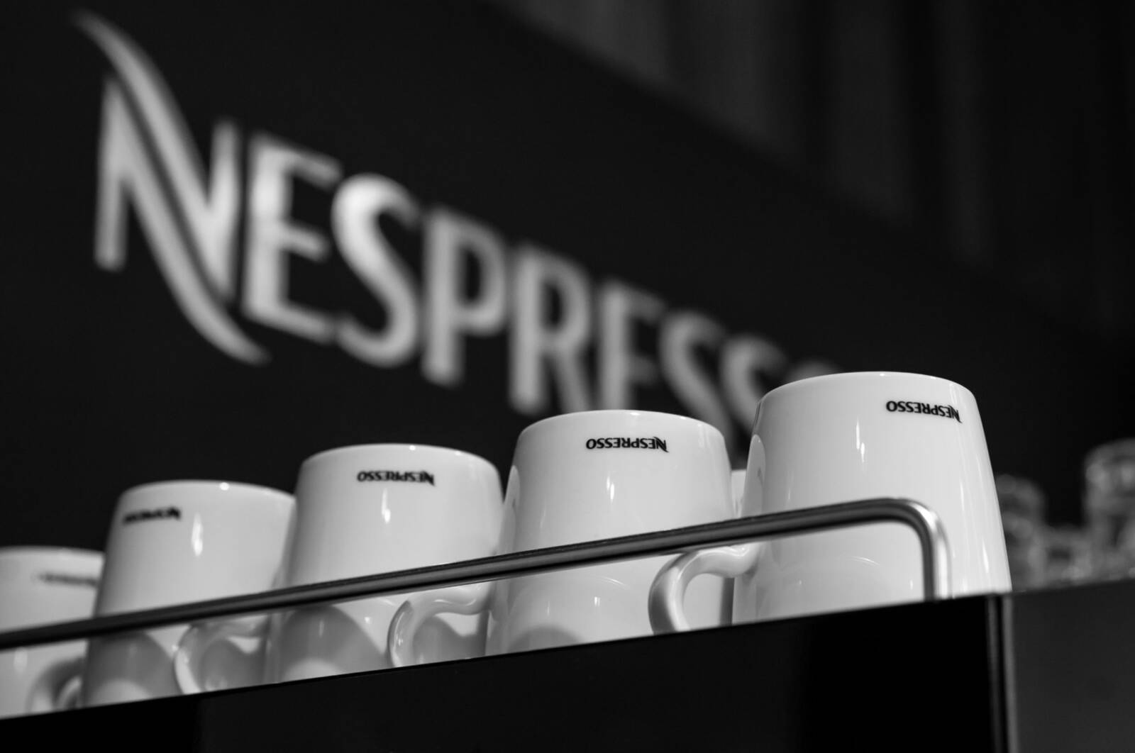 Stack of white Nespresso cups arranged on a dark background