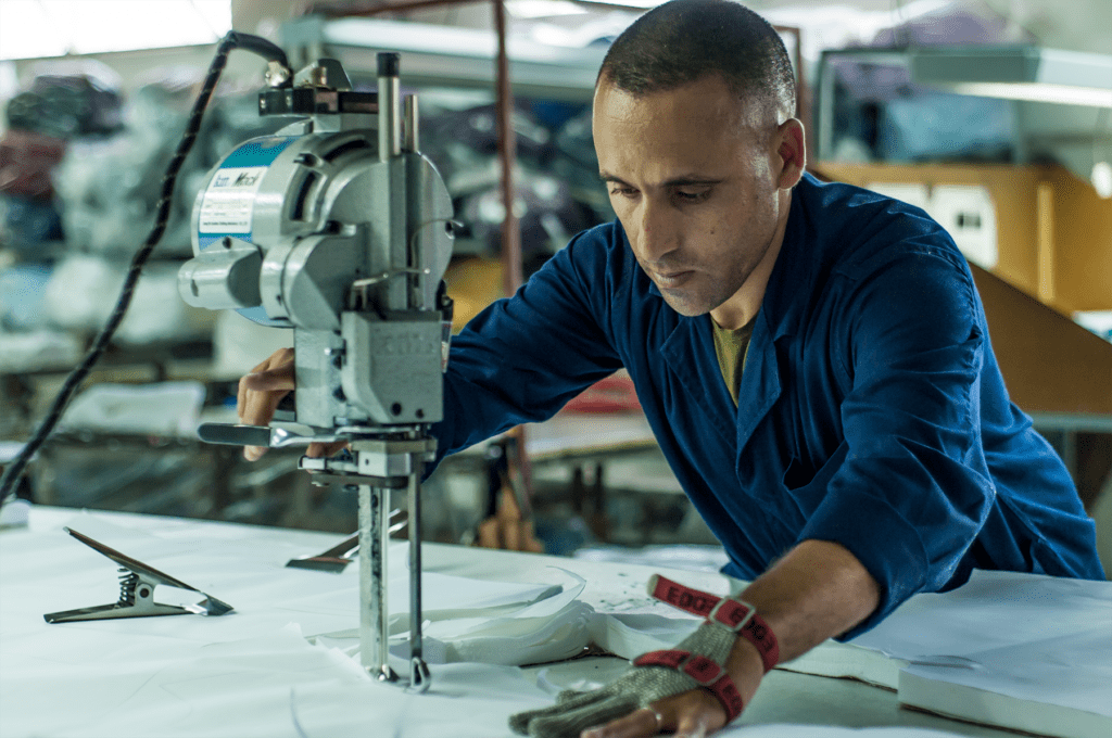 Factory worker operating an industrial sewing machine in a Moroccan textile factory