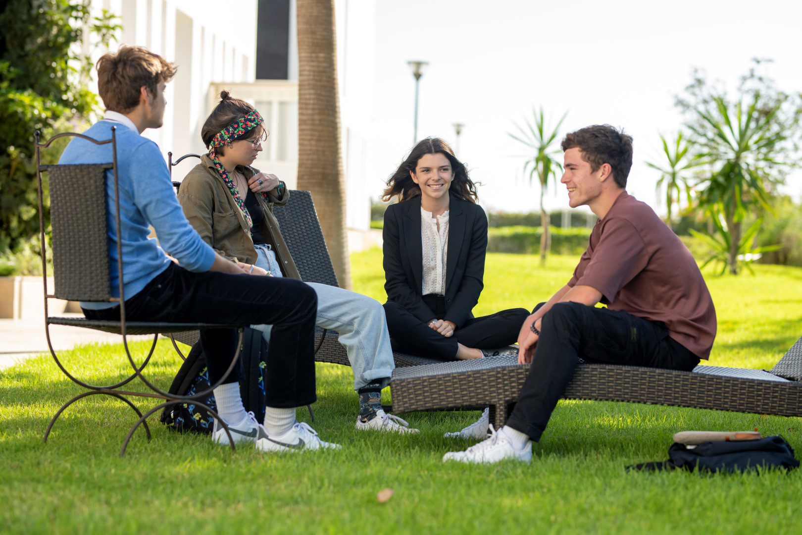Students relaxing together on outdoor benches on the ESSEC Afrique-Atlantique campus in Rabat