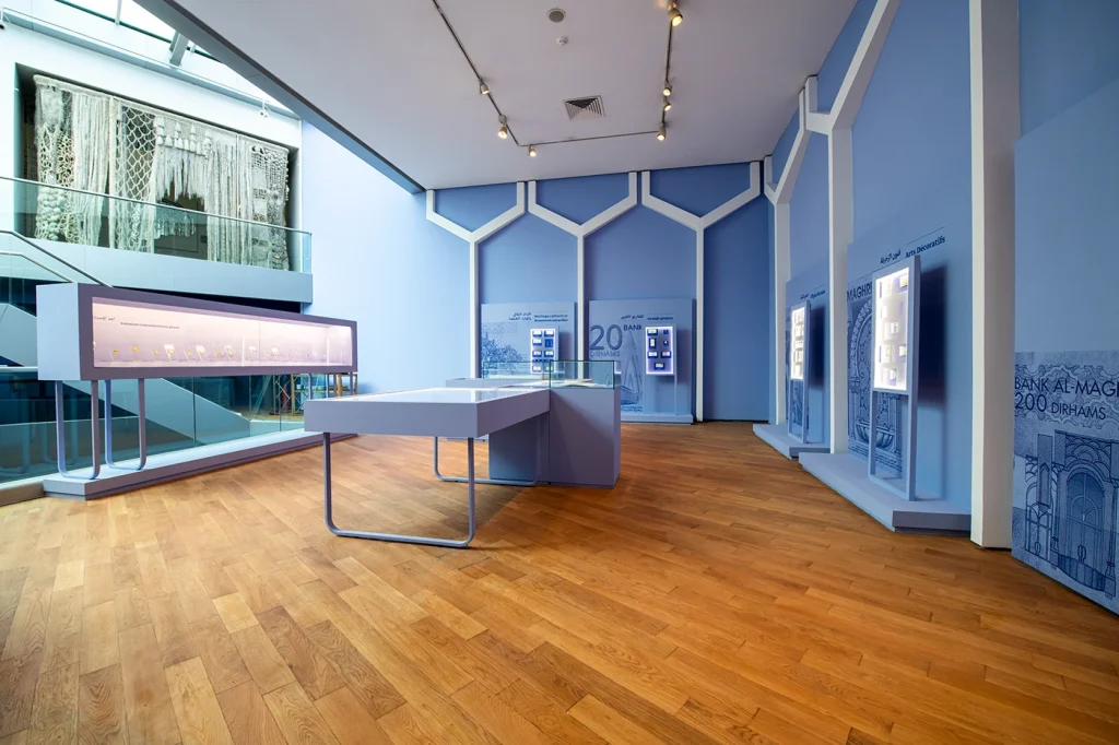 Blue-lit museum gallery with display cases inside the Bank Al-Maghrib numismatic museum in Rabat