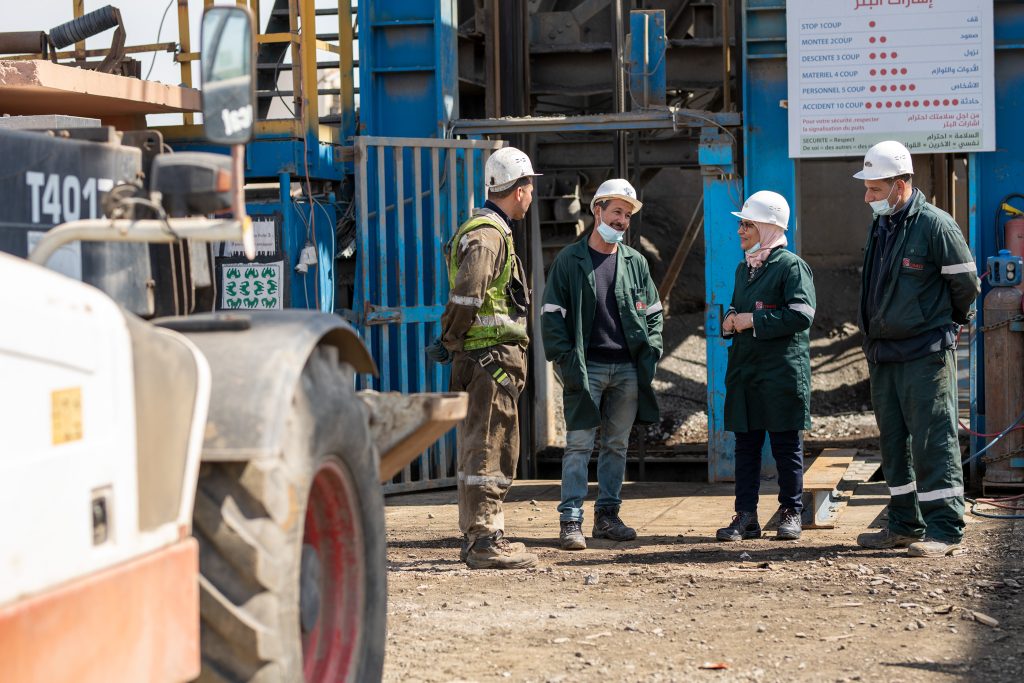 Workers in hard hats at a Moroccan mining and mineral-processing site during a Danish industrial delegation visit