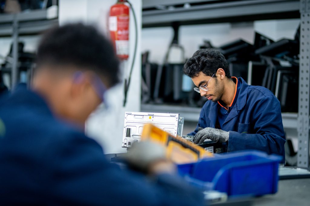 Two men working together at a workshop table, for the Invest For Jobs employment initiative